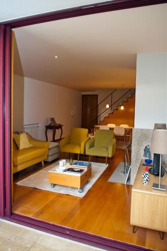 a living room with yellow and green furniture at Civitá Design & Accommodation in Braga