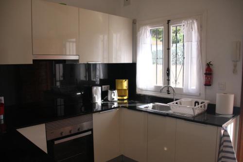 a kitchen with a black counter top and a sink at Vista Bahia II Apartments- top floor with balcony views & ground floor with garden and BBQ in Albir