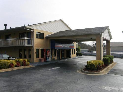 a building with a car parked in a parking lot at Rodeway Inn Jonesboro - Atlanta South in Jonesboro