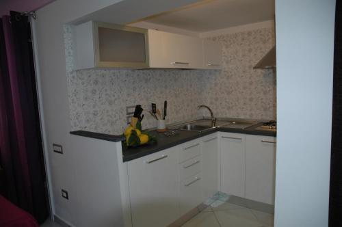a kitchen with white cabinets and a sink at Casa Duomo in Amalfi