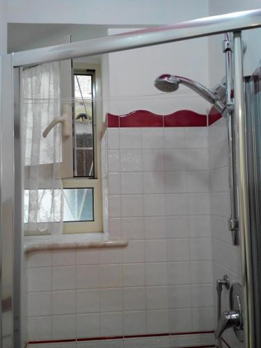 a bathroom with a shower with a mirror and a window at Casa Duomo in Amalfi