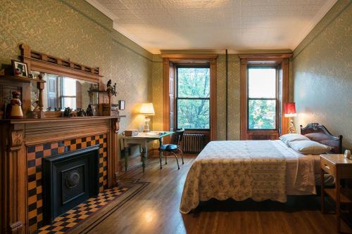 a bedroom with a bed and a fireplace and a desk at The Harlem Flophouse in New York