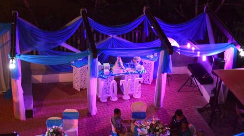 a purple and blue stage with a girl in a bed at Playa Aventura Hotel in Ayangue