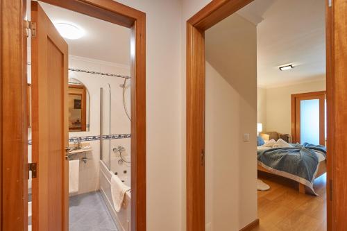 カスカイスにあるBeGuest Arribamar Apartmentのバスルーム(シャワー付)、ベッド1台が備わります。
