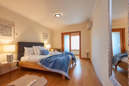 a bedroom with a bed with a blue blanket at BeGuest Arribamar Apartment in Cascais