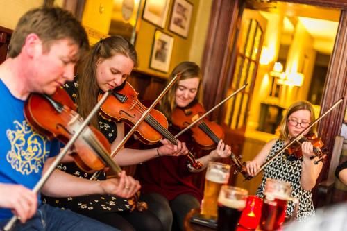 a group of people playing violins in a bar at Blarney Castle Hotel in Blarney