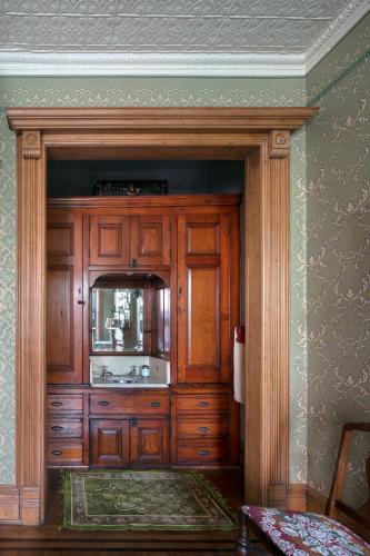a kitchen with wooden cabinets and a mirror at The Harlem Flophouse in New York