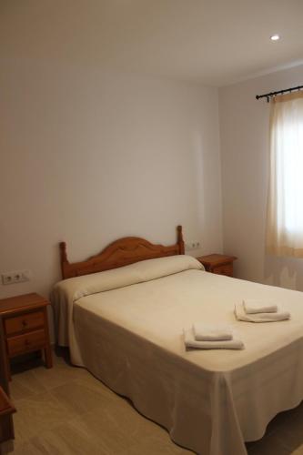 a bedroom with a bed with two towels on it at Apartamentos Rayma I-II-III in Cala Blanca