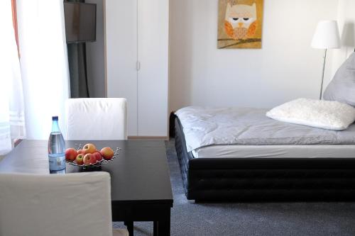 レラハにあるFerienwohnung Ewaのベッド1台、テーブル(フルーツボウル付)が備わる客室です。