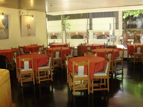 a restaurant with tables and chairs with red table cloth at Hotel Klee in Montevideo