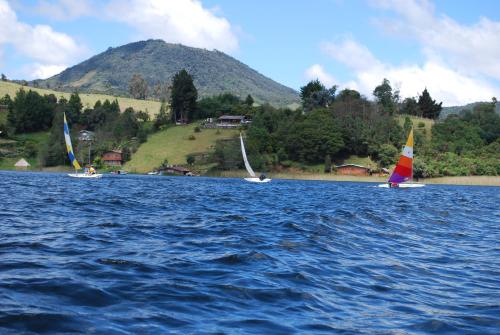 three sailboats on a lake with a mountain in the background at Hermosa Cabaña en La Cocha-Finca INDIANA in El Encano