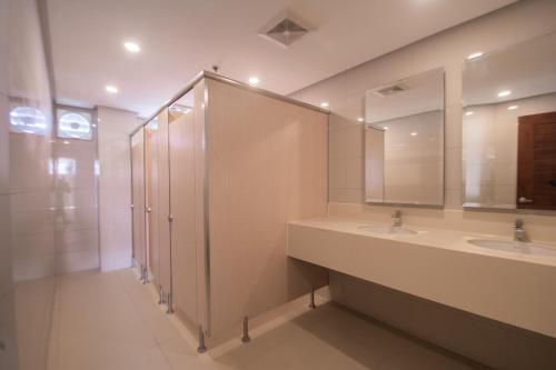 a bathroom with a shower, sink, and mirror at Shore Time Dormitel in Boracay