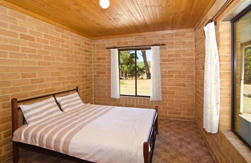 a bedroom with a bed in a brick wall at Turner Brook Chalet in Augusta