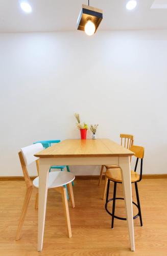 a dining room table with chairs and a light fixture at Kirakuan Luxury 2BR Pool/Gym in Ho Chi Minh City