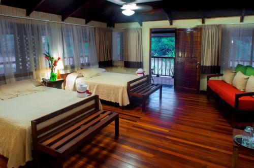 een slaapkamer met 2 bedden en een bank bij Selva Verde Lodge in Sarapiquí