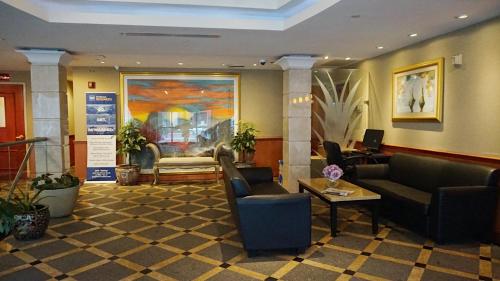 a lobby with couches and chairs in a building at Best Western Queens Court in Queens