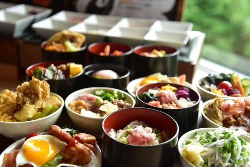 einen Tisch mit Schalen verschiedener Arten von Lebensmitteln in der Unterkunft Sahoro Resort Hotel in Shintoku