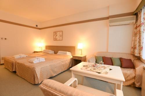 a hotel room with two beds and a couch at Sahoro Resort Hotel in Shintoku