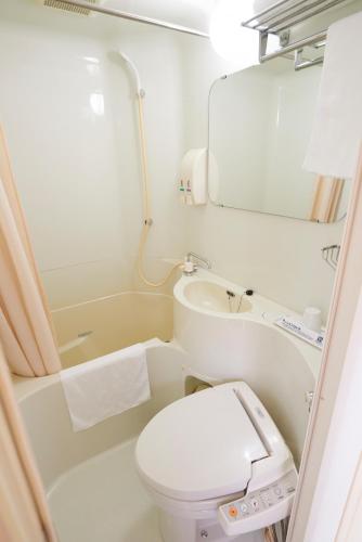 a small bathroom with a toilet and a sink at Super Hotel Kadoma in Kadoma