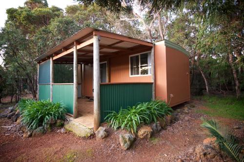 a small house with a green and orange exterior at Gracetown Caravan Park in Gracetown