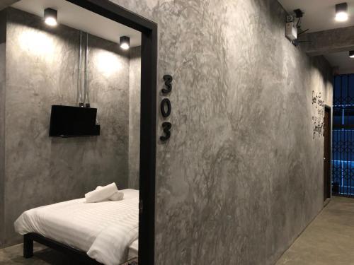 a bedroom with a bed with a mirror and a television at Blackjack Bar and Hostel in Chaweng