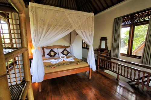 a bedroom with a bed with a canopy at Ben's Homestay in Ubud