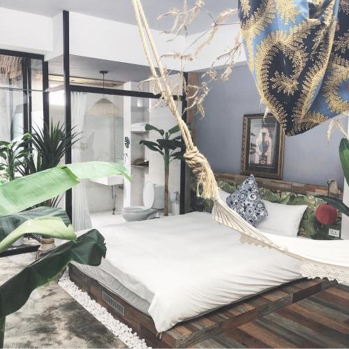 a hammock bed in a room with plants at Fas BnB in Jiali