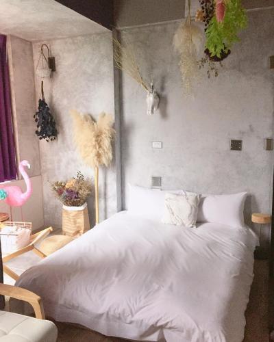 a bedroom with a white bed and a pink flamingo at Fas BnB in Jiali