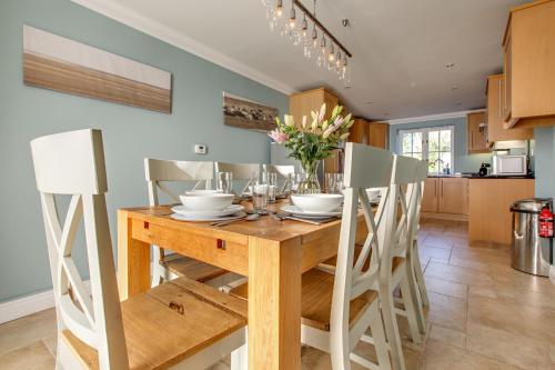 a kitchen and dining room with a wooden table and chairs at Tolly House in Wells next the Sea