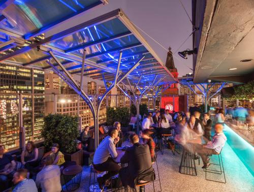 a group of people sitting in chairs at a bar at Mercure Brisbane King George Square in Brisbane