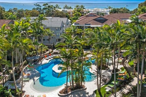 een luchtzicht op een resort met een zwembad en palmbomen bij Noosa Beach Apartment on HASTING ST French quarter resort.Noosa Heads in Noosa Heads