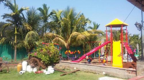 a childrens playground with a slide and a play equipment at Sea Land Kihim in Alibaug