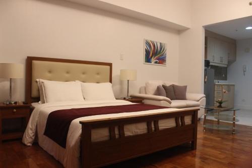 1 dormitorio con 1 cama grande y 1 sofá en Mosaic Tower by Funsho, en Manila