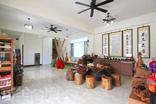 a living room with wooden stools and a ceiling at Sunny Lucy in Lugu