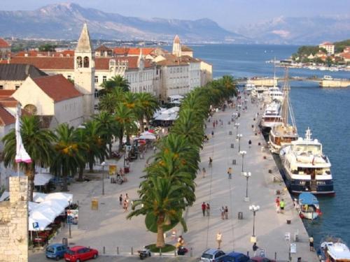 a city street with palm trees and boats in the water at Apartment Simone in Split