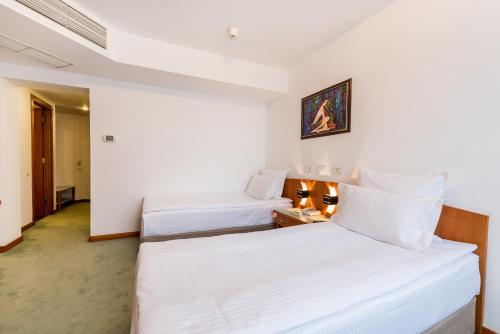 Ένα ή περισσότερα κρεβάτια σε δωμάτιο στο Hotel Duke Romana City Center