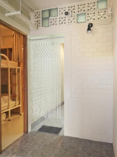 a shower in a room with a white brick wall at Silla House in Hat Yai