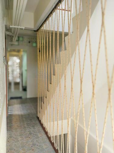 a hallway with a staircase with gold metal railing at Silla House in Hat Yai