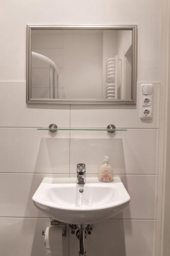 een badkamer met een witte wastafel en een spiegel bij Apartment Widey Str. 54 in Witten