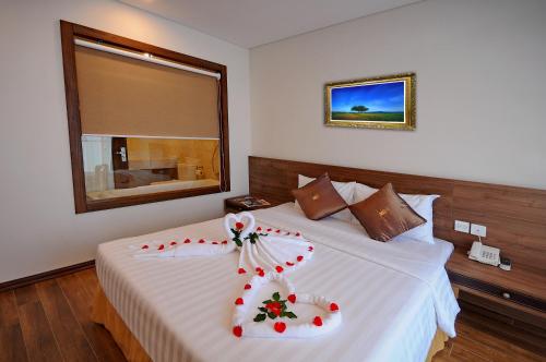 a bedroom with a bed with a flower decoration on it at Lenid Ocean View Hotel in Nha Trang