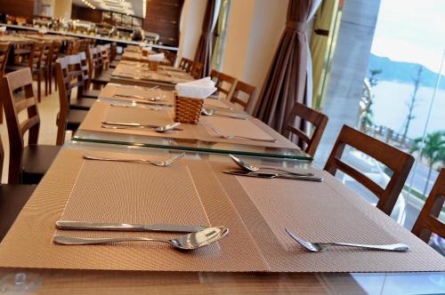 a long table in a restaurant with silverware on it at Lenid Ocean View Hotel in Nha Trang