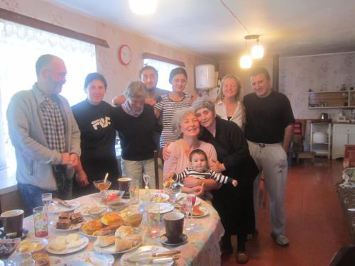 a group of people standing around a table with food at Ecohouse Svaneti in Mestia