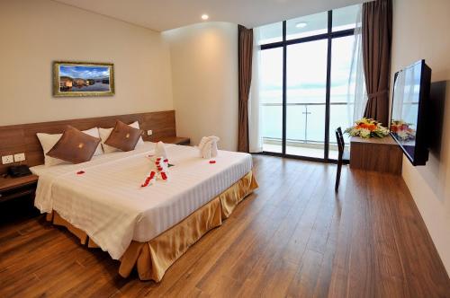 a bedroom with a large bed and a large window at Lenid Ocean View Hotel in Nha Trang