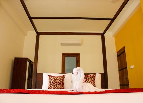 ヒッカドゥワにあるVilla Marinaのベッドルーム1室(白鳥の像が置かれたベッド1台付)