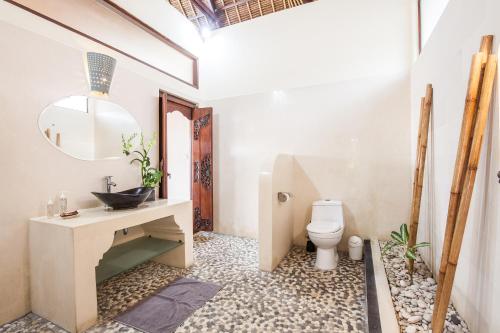 a bathroom with a sink and a toilet at Alizee Villa in Seminyak
