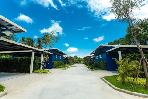 a road between two blue buildings with a blue sky at P House in Kanchanaburi City