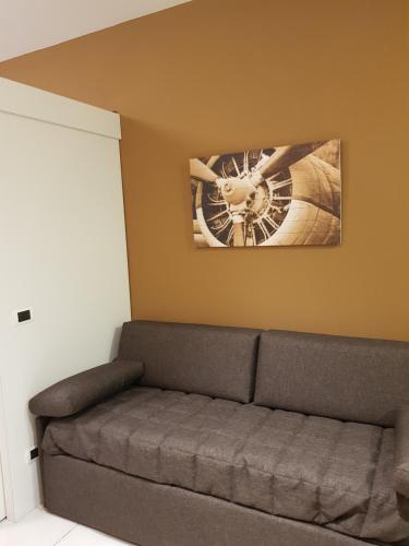 a couch in a room with a picture of a bike on the wall at Le Casette Di Osvaldo in Lecco