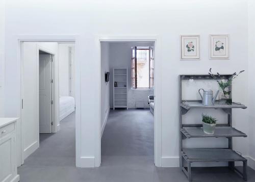 a hallway with white walls and a room with a shelf at Splendid houses in Valencia in Valencia