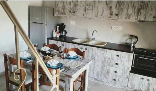 a kitchen with a table with chairs and a sink at Studio Galatia, in the heart of Kamilari in Kamilari