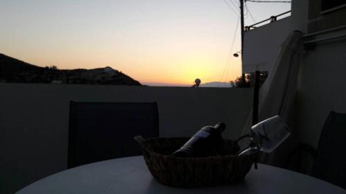 a basket on a table with the sunset in the background at Studio Galatia, in the heart of Kamilari in Kamilari